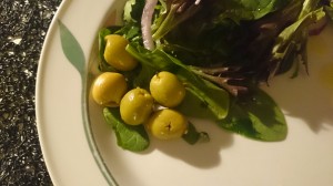 Förbereder middagen med sallad och oliver